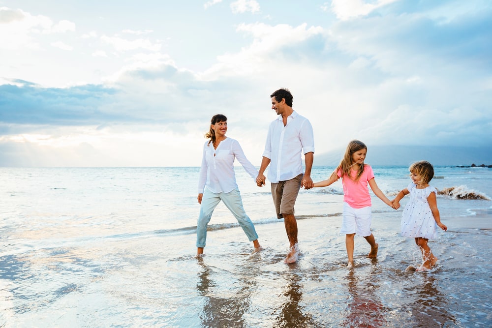 family walking on the beach holding hands