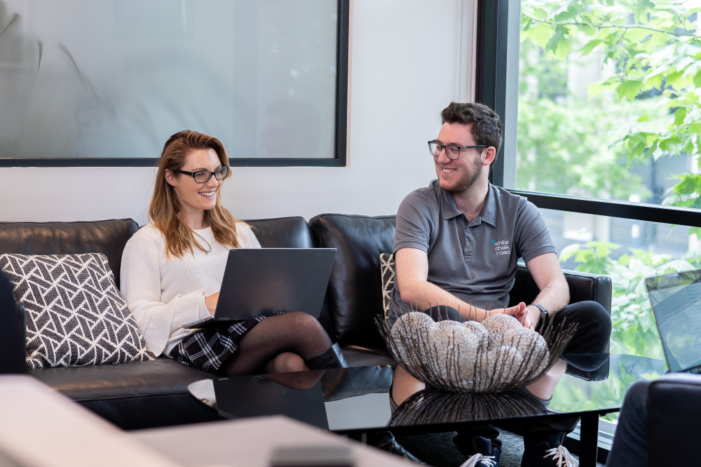 Felicity and Matt sitting on couch with laptops