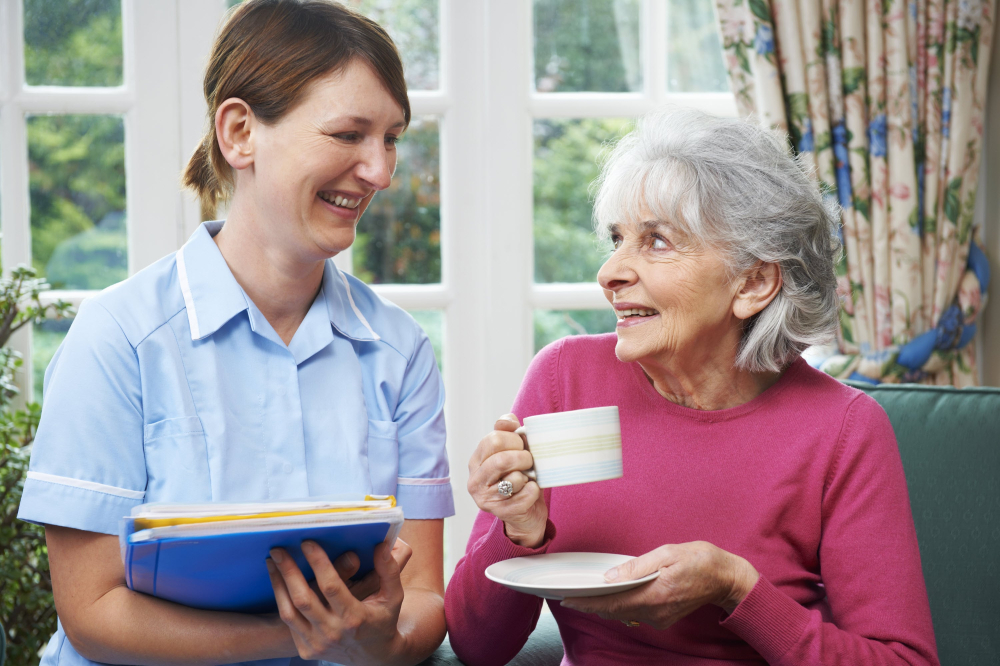 Carer helping older woman in assisted living community.