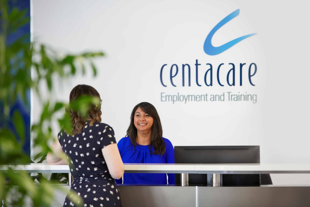 Receptionist with guest at Centacare office in Perth CBD.