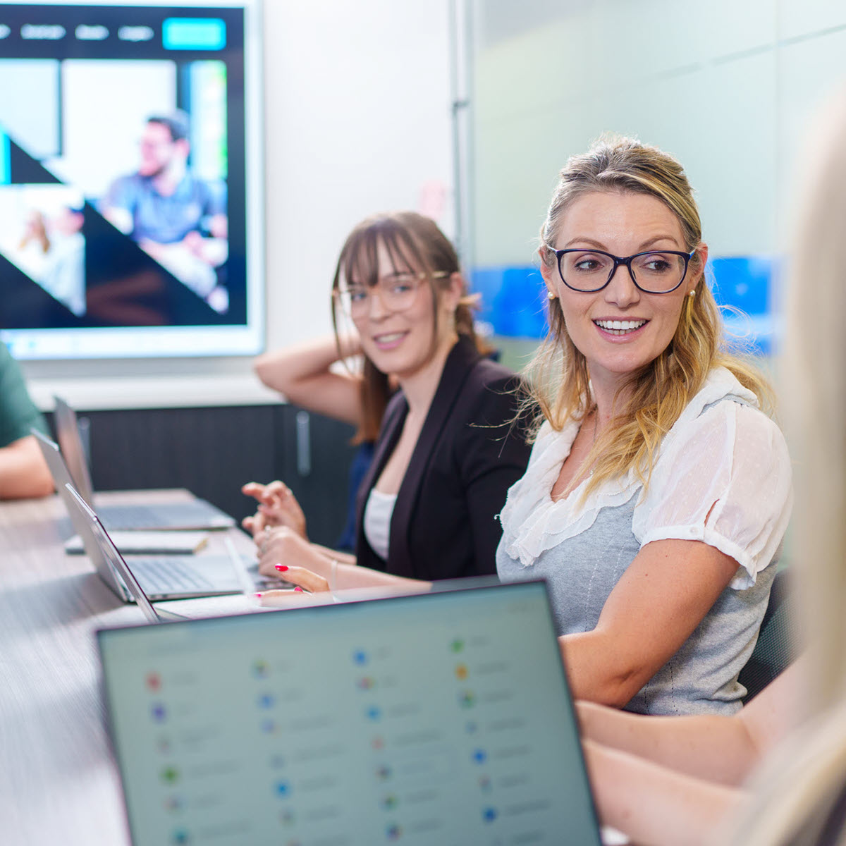 people sitting at a table looking at computers